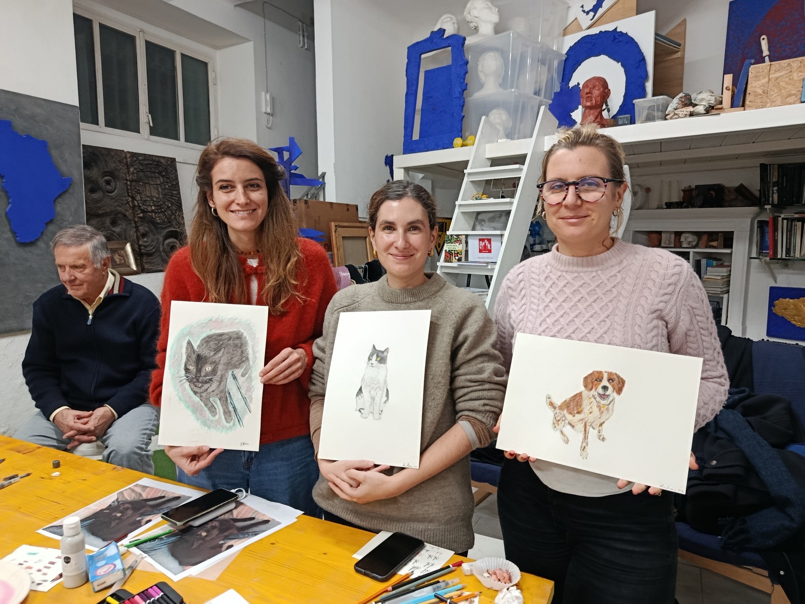 Three participants showing the portraits of their pets